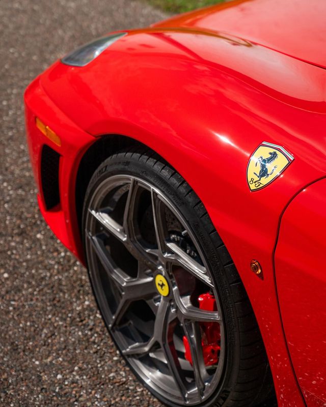 a red ferrari with a yellow sticker on the side